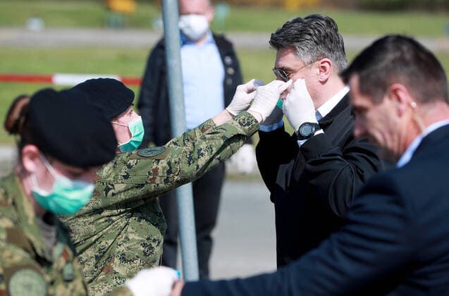 (200322) -- ZAGREB, March 22, 2020 -- Croatian President Zoran Milanovic (2nd R) wears a mask with the help of a soldier as he inspects a medical camp built by soldiers to accommodate COVID-19 patients at the parking lot of Clinical Hospital Dubrava in Zagreb, Croatia, on March 21, 2020. Croatia confirmed 78 new cases of COVID-19 infection in the past 24 hours as of Saturday afternoon, with the total number now at 206. Since the start of the outbreak on Feb. 25, it s the biggest daily increase of confirmed cases. ( Pixsell via Xinhua) CROATIA-ZAGREB-COVID-19-ZORAN MILANOVIC SanjinxStrukic 
