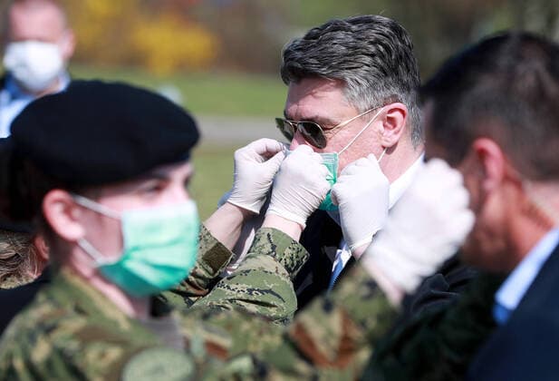 (200322) -- ZAGREB, March 22, 2020 -- Croatian President Zoran Milanovic (2nd R) wears a mask with the help of a soldier as he inspects a medical camp built by soldiers to accommodate COVID-19 patients at the parking lot of Clinical Hospital Dubrava in Zagreb, Croatia, on March 21, 2020. Croatia confirmed 78 new cases of COVID-19 infection in the past 24 hours as of Saturday afternoon, with the total number now at 206. Since the start of the outbreak on Feb. 25, it s the biggest daily increase of confirmed cases. ( Pixsell via Xinhua) CROATIA-ZAGREB-COVID-19-ZORAN MILANOVIC SanjinxStrukic 
