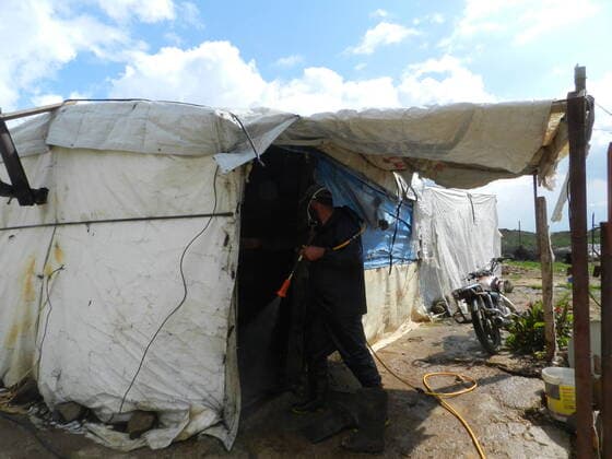 (200322) -- BEIRUT, March 22, 2020 (Xinhua) -- A man disinfects a Syrian refugee camp in southern Lebanon on March 21, 2020. Syrian refugee camps and houses in southern Lebanon were disinfected Saturday by local authorities. Lebanon s number of COVID-19 cases increased on Saturday to 206, the National News Agency reported, quoting the health ministry. (Photo by Taher Xinhua) LEBANON-BEIRUT-REFUGEE CAMPS-DISINFECTION 