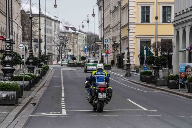 March 22, 2020, Munich, Bavaria, Germany: A motorcycle cop in Munich, Germany patrols the streets for violations of the Infektionsgesetz (anti-infection law) during the partial lockdown of the state. Displays of the empty streets and city center of Munich, Germany after restrictions on public life were put into force. The Interior Ministry has stated that cold weather, rain, and snow is a positive in this case. In comparison to a complete ban, Bavaria still allows highly restricted movement outside of the home and police are prepared act against violations. Munich Germany - ZUMAb160 20200322_zbp_b160_038 Copyright: xSachellexBabbarx