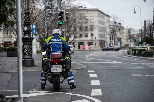 March 22, 2020, Munich, Bavaria, Germany: A motorcycle cop in Munich, Germany patrols the streets for violations of the Infektionsgesetz (anti-infection law) during the partial lockdown of the state. Displays of the empty streets and city center of Munich, Germany after restrictions on public life were put into force. The Interior Ministry has stated that cold weather, rain, and snow is a positive in this case. In comparison to a complete ban, Bavaria still allows highly restricted movement outside of the home and police are prepared act against violations. Munich Germany - ZUMAb160 20200322_zbp_b160_039 Copyright: xSachellexBabbarx