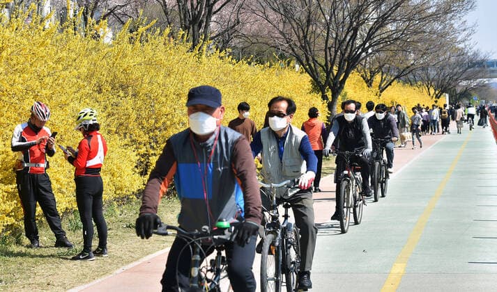 (200322) -- SEOUL, March 22, 2020 -- People ride bikes in Daegu, South Korea, March 22, 2020. South Korea reported 98 more cases of the COVID-19 compared to 24 hours ago as of midnight Sunday local time, raising the total number of infections to 8,897. (Newsis Handout via Xinhua) SOUTH KOREA-COVID-19 WangxJingqiang 