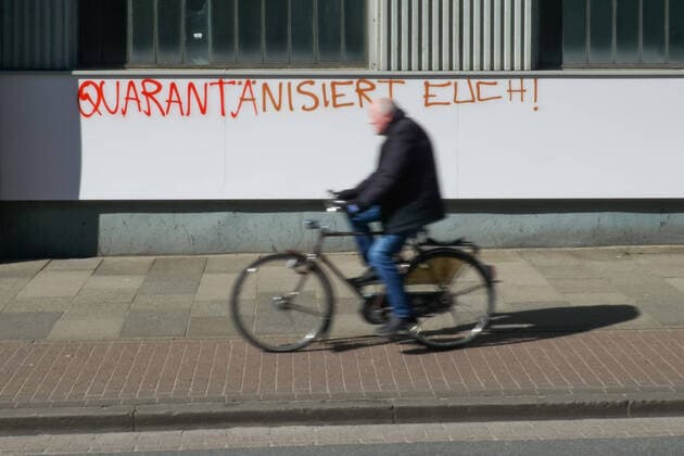 To contain the coronavirus, business closures have been ordered and curfews are being discussed, the photo shows a cyclist, cyclist in front of a graffiti, lettering on a building with the inscription Quarantine yourself, 22 03 2020, Bremen Germany , News, Feature, Coronavirus Bremen xobx