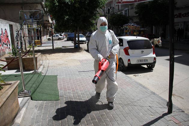 (200322) -- GAZA, March 22, 2020 -- A Palestinian volunteer sterilizes a street in Gaza City, March 22, 2020. Two Palestinians in Gaza have tested positive for COVID-19, becoming the first cases recorded in the Hamas-ruled enclave, a health official said early Sunday. A total of 53 Palestinians have been infected with the virus since March 5, and 17 of them have recovered, the health ministry in the West Bank said earlier Saturday. (Photo by Rizek Abdeljawad Xinhua) MIDEAST-GAZA-COVID-19 xiongsihao 