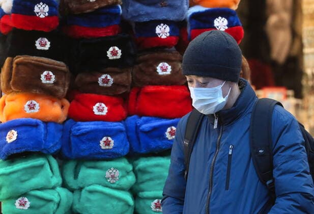 MOSCOW, RUSSIA - MARCH 22, 2020: A man in a face masks walks past a gift shop amid the ongoing COVID-19 pandemic. Sergei Savostyanov TASS  TS0D30E8
