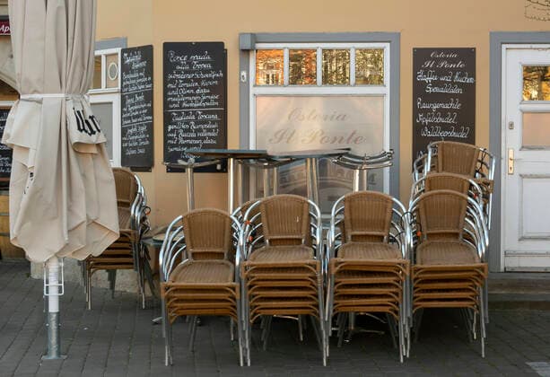 Stuehle stehen vor einem geschlossenen Restaurant auf dem Wenigemarkt am 22.03.2020 in Erfurt. search: Deutschland Thueringen Aussenaufnahme Tourismus Tourismuskrise Stadt Stadtansicht Gastronomie Restaurant Restaurants keine Gaeste Umsatzausfall Umsatzausfaelle schliessen geschlossen Schliessung Pleite Umsaetze Umsatzrueckgang Ueberleben gastronomisch Dienstleistung laufende Kosten Miete ausbleibende Einnahmen Leere Stuhl Stuehle flaute Soziales Sozial Gesundheit Krise Coronakrise Krankheit Uebertragung uebertragen sozial soziale Kontakt Kontakte Infektion Schmierinfektion infizieren anstecken Ansteckung minimieren Ansteckungsgefahr sperren gesperrt Sicherung Sicherheit Anordnung Ansteckung Ausgangssperre Behoerden COVID-19 Corona Coronavirus Virus Covid Covid-19 Covid19 Covid 19 Coronaepidemie Epedemie Pandemie Coronainfektion Coron