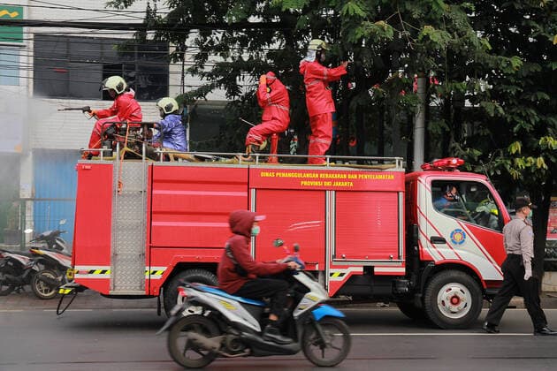 Spraying disinfectant to prevent the spread of COVID-19 in Jakarta - 22 March 2020. Indonesian firefighter spray disinfectant in the road in Jakarta, Indonesia, on March 22, 2020. Spraying to prevent the spread of COVID-19. that continues to plague. (Photo by Yogi Aroon Sidabariba INA Photo Agency imago images) 