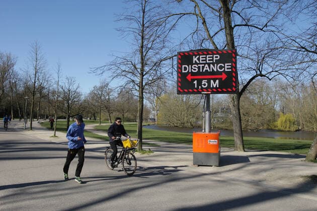 People running and ride bicycles pass a sign urging people to practice social distancing and keep 1.5 meters at the Vondelpark on March 22, 2020 in Amsterdam,Netherlands.The Dutch government ordered all Dutch schools, cafes, restaurants, coffeeshops, sex clubs and sport and fitness clubs to be closed as the government sought to prevent the further spread of coronavirus in the Netherlands. Amsterdam Netherlands Copyright: xPauloxAmorimx PAWP2M4B0830