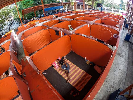 (200323) -- MANILA, March 23, 2020 -- A man sleeps in a modular tent set up for street dwellers to stop the further spread of COVID-19 at a sheltered basketball court in Manila, the Philippines on March 23, 2020. The Philippine health authorities confirmed on Sunday 73 new cases of COVID-19 in the country, bringing the total number of people sick with the highly contagious disease to 380. ) PHILIPPINES-MANILA-COVID-19-MODULAR TENTS ROUELLExUMALI 