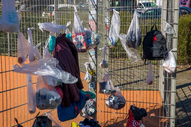 To help the needy and homeless, residents of the Leipzig district of Connewitz hung bags of food, toiletries, clothing, pet food and other groceries on the fence of a basketball court