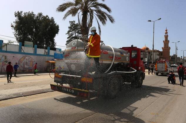 March 23, 2020, Khan Younis, Gaza Strip, Palestinian Territory: Palestinian Members of the Civil Defense disinfect the streets, as a preventive measure amid fears of the spread of the coronavirus, in Khan Younis in the southern of Gaza strip, on March 23, 2020. The Palestinian Health Ministry today reported its first two cases of the novel coronavirus in the Gaza Strip. undertook serious measures to preempt the arrival of the virus to the strip. Up until its decision to seal off its sides of the Rafah crossing with Egypt and the Erez checkpoint with Israel, hundreds of Palestinians who entered the strip were immediately quarantined to ensure they had no symptoms of the disease Khan Younis Palestinian Territory - ZUMAap3_ 20200323_zaf_ap3_117 Copyright: xAshrafxAmrax