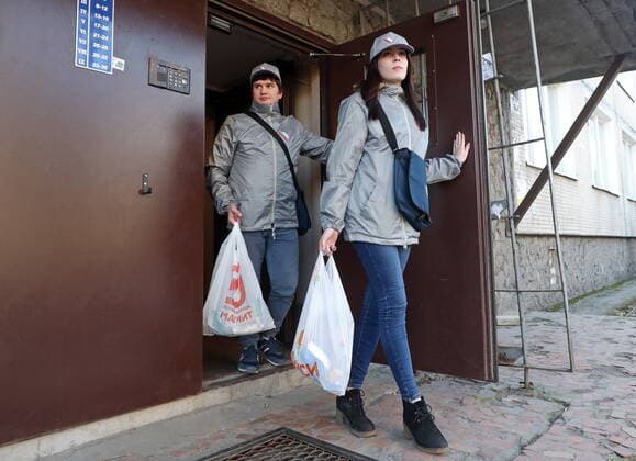 ST PETERSBURG, RUSSIA - MARCH 23, 2020: Medical volunteers delivering groceries to elderly people in quarantine amid the COVID-19 coronavirus pandemic. Medical volunteers and the Russian Popular Front are opening volunteer centers to help the elderly who are at higher risk of COVID-19 and are staying at home to avoid the coronavirus infection. Alexander Demianchuk TASS  TS0D3246