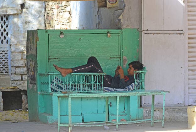 India: Janta Curfew in Rajasthan A young man uses mobile phone near a closed market during Janta Curfew in the wake of coronavirus pandemic in Beawar. Beawar Rajashan India Copyright: SumitxSaraswat