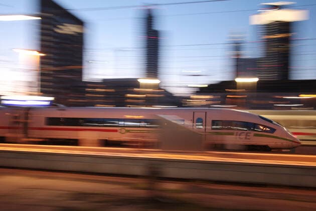 ICE 3 of DB Deutsche n Bahn with green em band at departure from Frankfurt main station at dusk, Hesse, Germany
