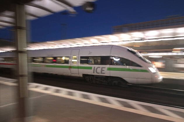 ICE 3 of DB Deutsche n Bahn with green em band at departure from Frankfurt main station at dusk, Hesse, Germany