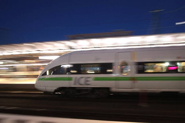 ICE 3 of DB Deutsche n Bahn with green em band at departure from Frankfurt main station at dusk, Hesse, Germany