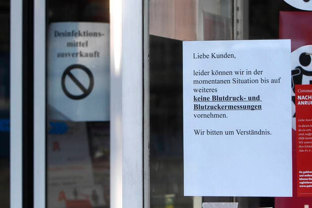 Posters with the words dear customers, unfortunately we are not able to perform blood pressure and blood sugar measurements in the current situation until further notice and disinfectants sold out at a closed pharmacy in the city center of Mannheim, Baden Württemberg, Germany