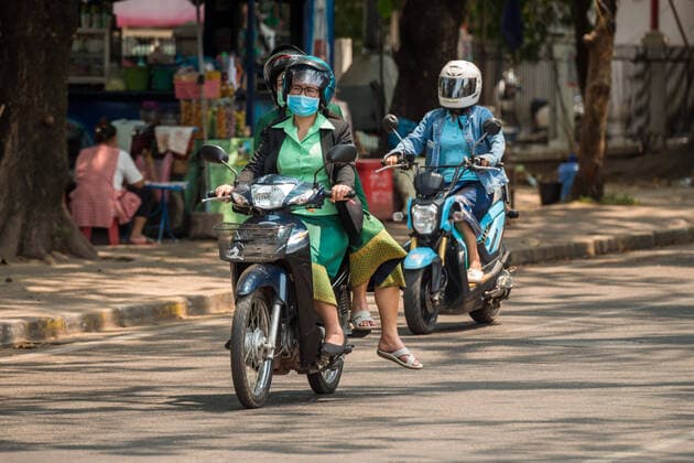 (200323) -- VIENTIANE, March 23, 2020 -- People wearing face masks ride motorbikes on the street in Vientiane, Laos, March 23, 2020. Lao people have taken preventive measures against the COVID-19, despite there being no confirmed case of the virus infection in Laos. (Photo by Kaikeo Saiyasane Xinhua) LAOS-VIENTIANE-COVID19-DAILY LIFE ZhangxJianhua 