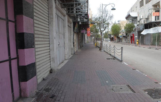 (200323) -- HEBRON, March 23, 2020 -- Photo taken on March 23, 2020 shows closed shops on an empty street in the West Bank City of Hebron. Palestinian authorities on Sunday declared a 14-day lockdown on the West Bank as part of measures to combat the spread of coronavirus pandemic. (Photo by Mamoun Wazwaz Xinhua) MIDEAST-HEBRON-COVID-19-MEASURES XiongxSihao 