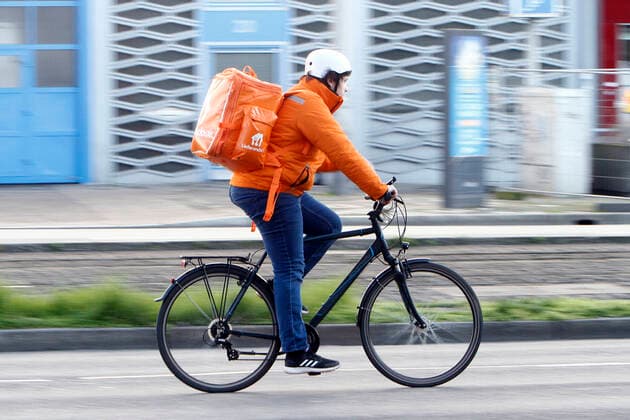 Bicycle courier from the Internet portal Lieferando delivers hot meals in downtown Mannheim, Hesse, Germany