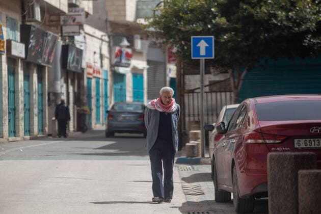 (200323) -- BETHLEHEM, March 23, 2020 -- A Palestinian man walks on an empty street in the West Bank City of Bethlehem, March 23, 2020. Palestinian authorities on Sunday declared a 14-day lockdown on the West Bank as part of measures to combat the spread of coronavirus pandemic. Prime Minister Mohammed Ishtaye announced a ban on transportation and movement between the West Bank districts, urging citizens to stay at home. (Photo by Luay Sababa Xinhua) MIDEAST-BETHLEHEM-COVID-19-MEASURES XiongxSihao 