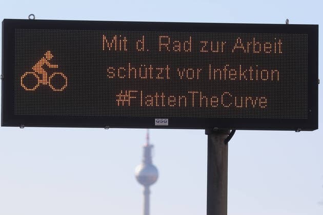 23 03 2020, Berlin, CEFR Note Cycling to work protects against infection In the background the Berlin TV tower everyday life, display, curfew, curfew, outside, outdoor shot, Berlin, corona epidemic, corona infe