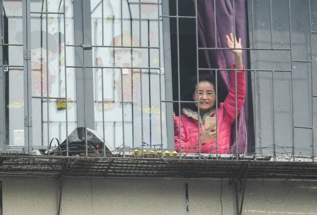 (200323) -- WUHAN, March 23, 2020 -- A resident waves goodbye to medics from Guangdong Province on their way to the airport in Wuhan, central China s Hubei Province, March 23, 2020. A total of 322 members of a medical assistance team from Guangdong Province left Wuhan of Hubei Province on Monday after finishing their task. ) CHINA-HUBEI-WUHAN-MEDICAL STAFF FROM GUANGDONG-DEPARTURE (CN) ChenxYehua 