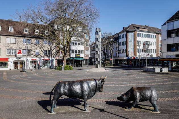 23 03 2020, Viersen, Niederrhein, Nordrhein Westfalen, Germany Contact ban due to corona pandemic, on Monday deserted shopping street with closed shops in the old town of Viersen, here bull and bear on the square in front of the Sparkasse at the main street Viersen Nordrhein Westfalen Germany
