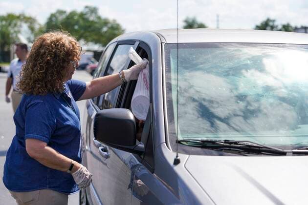 March 23, 2020, Tampa, Florida, USA: Kelley Brickfield hands ready-made meals over to people coming through at a drive-through distribution meal center set up by Feeding Tampa Bay. Volunteers handed out free kid s lunches and tomorrow s breakfast in response to the pandemic which has forced all area schools to close. On Monday, March 23, 2020 in Tampa. Tampa USA - ZUMAs70_ 20200323_zan_s70_010 Copyright: xMarthaxAsencioxRhinex