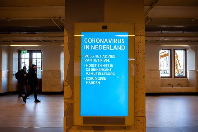 March 23, 2020, Amsterdam, Netherlands: A Coronavirus warming sign hangs at the Central train station..Since the Coronavirus hit The Netherlands, most of the cities are empty. A couple of weeks ago, Prime Minister Mark Rutte called to work from home as much as possible and also announced the closure of restaurants, sports clubs, sex clubs, saunas, and cafes. Amsterdam is not formally in lockdown, but the streets and squares are empty. Amsterdam Netherlands - ZUMAs197 20200323_zaa_s197_057 Copyright: xAnaxFernandezx