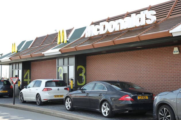 A McDonald s restaurant is busy at the drive-thru as people are only able to get their fast food from it until this evening, when Coronavirus COVID-19 is forcing it close it s doors. McDonald s, Spalding, Lincolnshire, UK, on March 23, 2020 