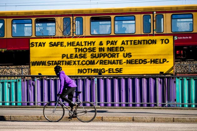 A cyclist rides in front of a sign saying Stay safe, healthy and pay attention to those in need in Berlin on 23 March 2020 To slow down the spread of the coronavirus COVID 19, the federal and state governments decided to impose further restrictions After museums, theatres, sports events etc.