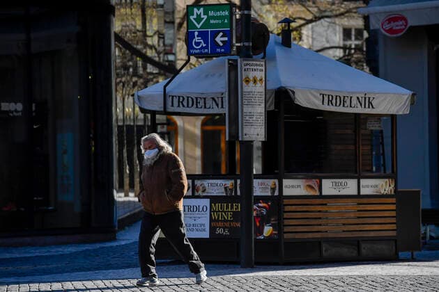 Lonely pedestrian wearing face mask walk by deserted Wenceslas Square in Prague, Czech Republic, March 23, 2020. (CTKxPhoto VitxSimanek) CTKPhotoP202003230831501 VIS 005