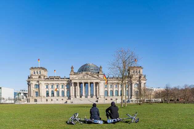 23 03 2020, Berlin, Germany, GER Impressions from Berlin during the curfew A couple sitting together in front of the deserted meadow at the Reichstag