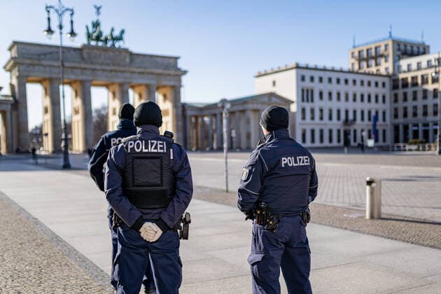 23 03 2020, Berlin, Germany, CEFR Impressions from Berlin during curfew Police officers are standing on the otherwise deserted Pariser Platz at Brandenburg Gate
