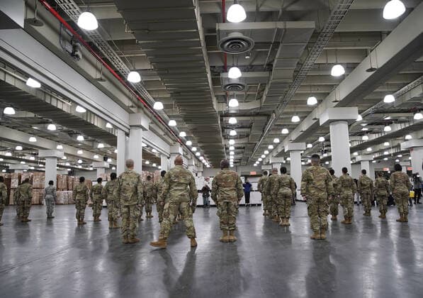 Members of the National Guard in uniform line up through at the Jacob Javits Convention Center before Gov. Andrew Cuomo speaks with the National Guard on site in New York City on Monday, March 23, 2020. The Javits Center is setting up to be turned into field hospitals to test and possibly treat cases of COVID-19 infections. New York state now accounts for about 1 percent of the coronavirus-related deaths in the world and New York City has more than 12,300 of those cases.  NYP20200323118 JOHNxANGELILLO