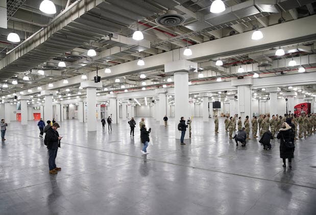 Members of the press space out but surround the uniformed members of the National Guard that are on site at the Jacob Javits Convention Center before Gov. Andrew Cuomo speaks with the National Guard on site in New York City on Monday, March 23, 2020. The Javits Center is setting up to be turned into field hospitals to test and possibly treat cases of COVID-19 infections. New York state now accounts for about 1 percent of the coronavirus-related deaths in the world and New York City has more than 12,300 of those cases.  NYP20200323124 JOHNxANGELILLO