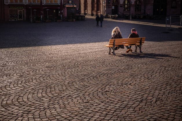 2 people on a bench on Frankfurts Römer during the time of the Corona Virus Frankfurt during rush hour