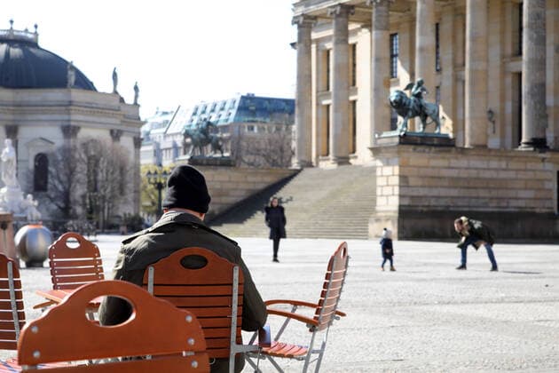 23 03 2020, Berlin Germany Corona crisis, Gendarmenmarkt, Man sunbathing, Family out for a walk, Day 1 according to the new regulations for containing the coronavirus, People should only go out on the streets for the most necessary things