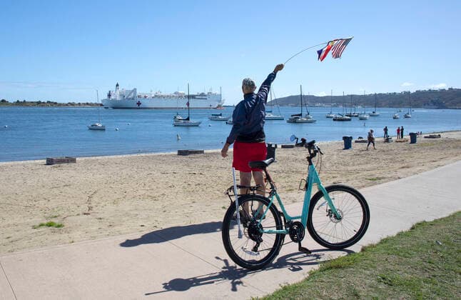 March 23, 2020, San Diego, CA, USA: Navy veteran Russell Ordiway waves to the San Diego-based Navy hospital ship USNS Mercy as it leaves San Diego Bay on its way to Los Angeles where it will provide overflow support for non-coronavirus patients amid the area s surge of coronavirus patients. San Diego USA - ZUMAga3_ 20200323_zap_ga3_002 Copyright: xJohnxGastaldox