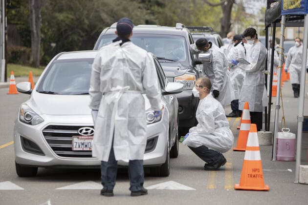 Hayward emergency-medical technicians check members of the public for symptoms and high temperature at a Coronavirus drive up triage station in Hayward, California on Monday, March 23, 2020. If the individual has symptoms, they are directed to be tested for CIVID-19 at a separate testing tent.  SFP2020032312 PETERxDASILVA