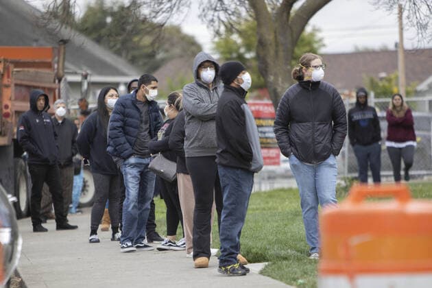 Members of the public practice social distancing while waiting in line to be checked by Hayward emergency-medical technician for symptoms and high temperature at a triage station for Coronavirus in Hayward, California on Monday, March 23, 2020. If the individual has symptoms, they are directed to be tested for CIVID-19 at a separate testing tent.  SFP2020032316 PETERxDASILVA