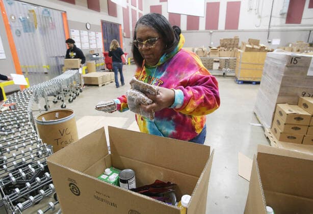 Volunteers pack food supplies for shut-in seniors at St. Louis Area Foodbank in Bridgeton, Missouri on Monday, March 23, 2020. The Foodbank is now supplying two months of seniors boxes in a single delivery so that seniors risk of social exposure is reduced due to Coronavirus concerns.  SLP2020032315 BILLxGREENBLATT