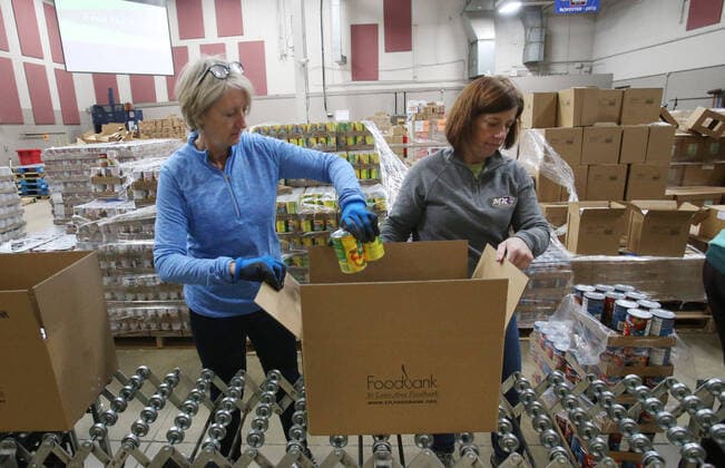Volunteers pack food supplies for shut-in seniors at St. Louis Area Foodbank in Bridgeton, Missouri on Monday, March 23, 2020. The Foodbank is now supplying two months of seniors? boxes in a single delivery so that seniors risk of social exposure is reduced due to Coronavirus concerns.  SLP2020032316 BILLxGREENBLATT