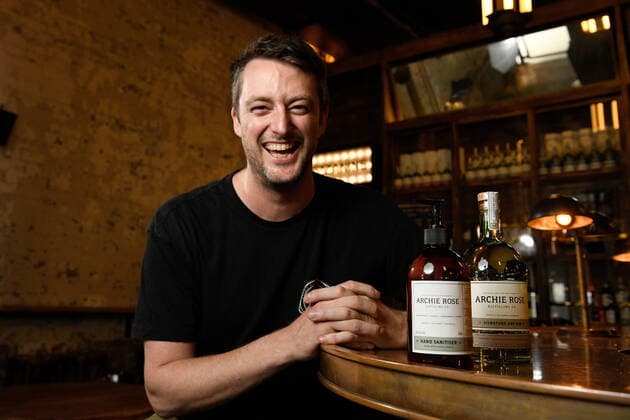 ARCHIE ROSE GIN HAND SANITISER, Archie Rose Distilling Group Bar Manager Lewis Jaffrey poses with a bottle of their Gin infused hand sanitiser and signature gin, in Sydney, Tuesday, March 24, 2020. Using leftover botanicals from their gin, the idea to produce the hand sanitiser came from trying to keep their bar staff employed during the COVID-19 shut down of license venues. The hand sanitiser has so far sold out online, but will be sold to the general public and wholesalers. ( NO ARCHIVING, EDITORIAL USE ONLY, NO USE IN BOOKS WITHOUT CONSENT SYDNEY NSW AUSTRALIA  Copyright: xBIANCAxDExMARCHIx 20200324001459061782