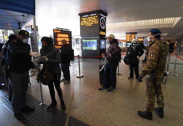 (200323) -- ROME, March 23, 2020 (Xinhua) -- A policeman checks a passenger s documents at Roma Termini railway station in Rome, Italy, on March 23, 2020. The COVID-19 pandemic had claimed 6,077 lives in locked down Italy by Monday, with the cumulative number of confirmed cases reaching 63,927, according to new figures released by the Civil Protection Department. (Photo by Augusto Casasoli Xinhua) ITALY-ROME-COVID-19-CASES 