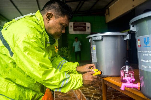 March 24, 2020, Makassar, South Sulawesi, Indonesia: An employee washing his hands with clean water in a bucket before entering his office in Makassar, South Sulawesi Province, Indonesia. Pasar Makassar Raya Regional Company, requires its employees to clean their hands before working in the office and calls for compliance with social distance to prevent the spread of Covid-19. At present, there are more than 686 patients with symptoms of Covid-19 in Indonesia. Makassar Indonesia - ZUMAb223 20200324_zip_b223_005 Copyright: xHerwinxBaharx