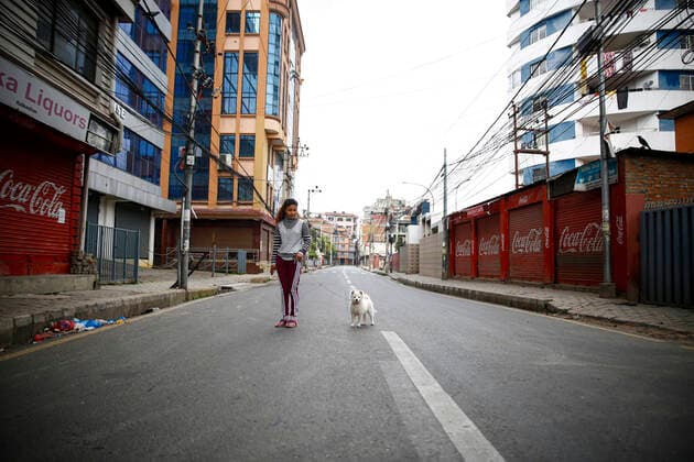 March 24, 2020: A woman and her dog walk the empty roads after the government imposed a nationwide lockdown for a week in an effort to control the spread of COVID-19 after Nepal confirmed the second case of a 19-year-old Nepali student, who had returned from France via Qatar in Kathmandu, Nepal on Tuesday, March 24, 2020. Photo . - ZUMAg200 20200324_zap_g200_004 Copyright: xSkandaxGautamx