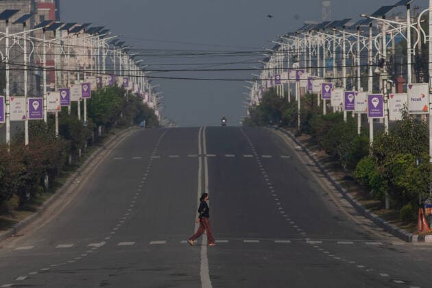 March 24, 2020, Kathmandu, Nepal: A woman walks across a deserted road during the lock down in Kathmandu..Nepal government has decided to lock down the whole country from 24 March till 31 March following a second confirmed COVID-19 case. Kathmandu Nepal - ZUMAs197 20200324_zaa_s197_022 Copyright: xPrabinxRanabhatx