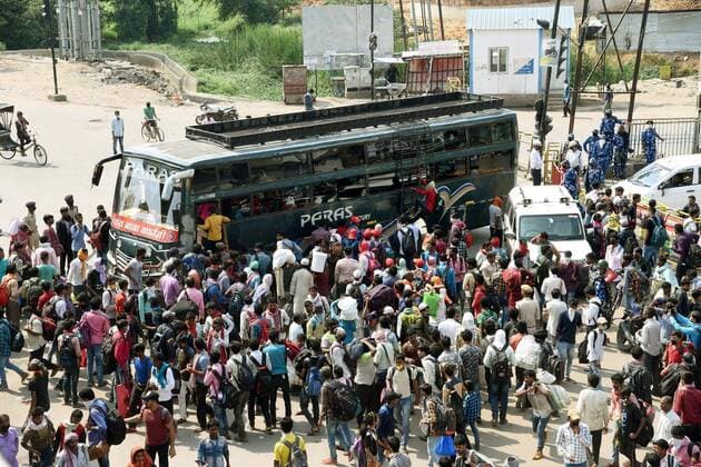 PATNA, INDIA - MARCH 23: Commuters try to board an overcrowded bus during the first day of lockdown imposed by the state government to curb the spread of coronavirus in Patna, Bihar India on Monday March 23, 2020. (Photo Santosh Kumar Hindustan Times) First day Of Lockdown In Patna
